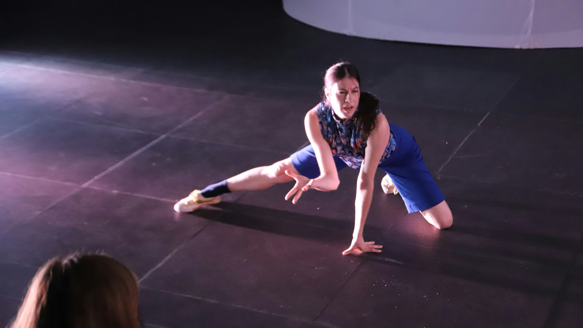 Eine Tänzerin macht einen Ausfallschritt.