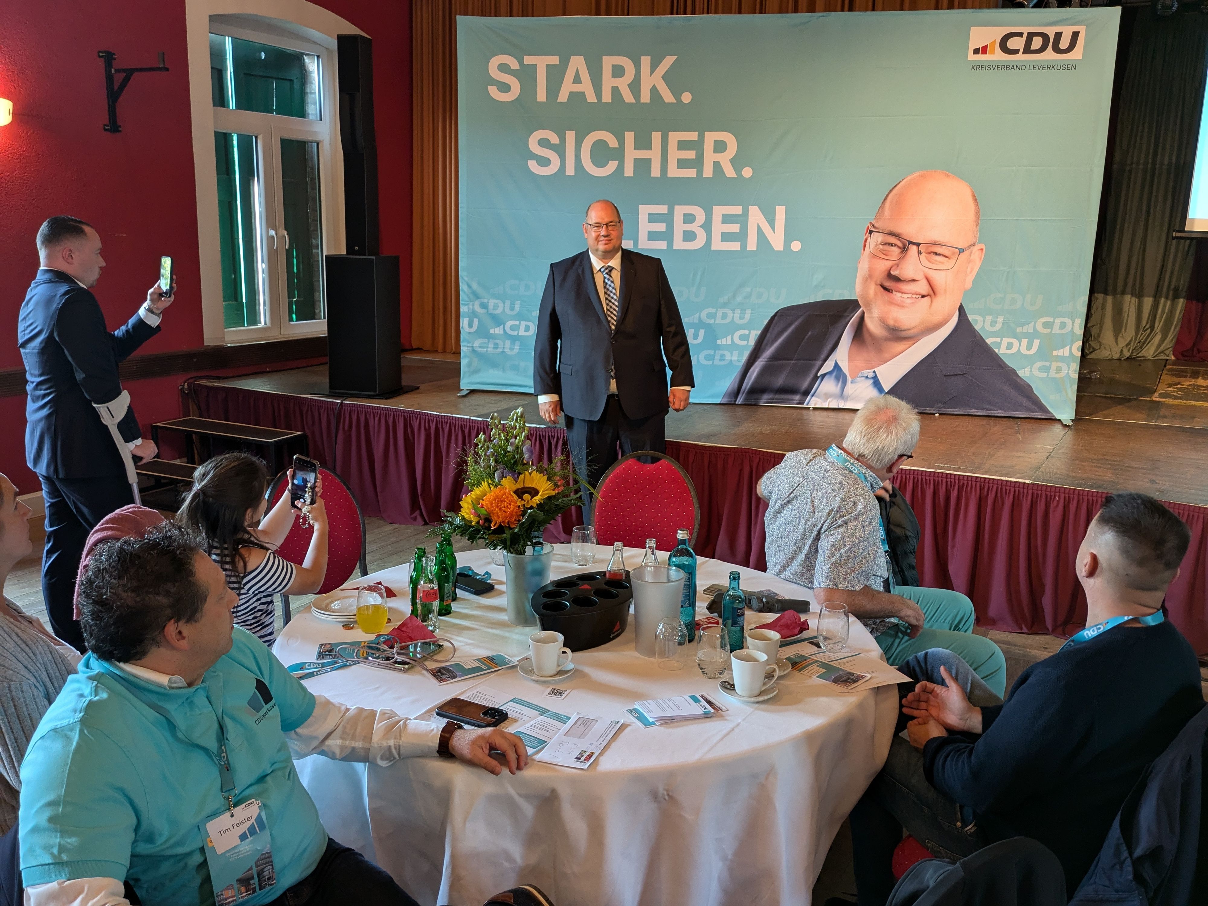 Ein Mann steht vor einem CDU-Plakat, auf dem er selbst abgebildet ist.