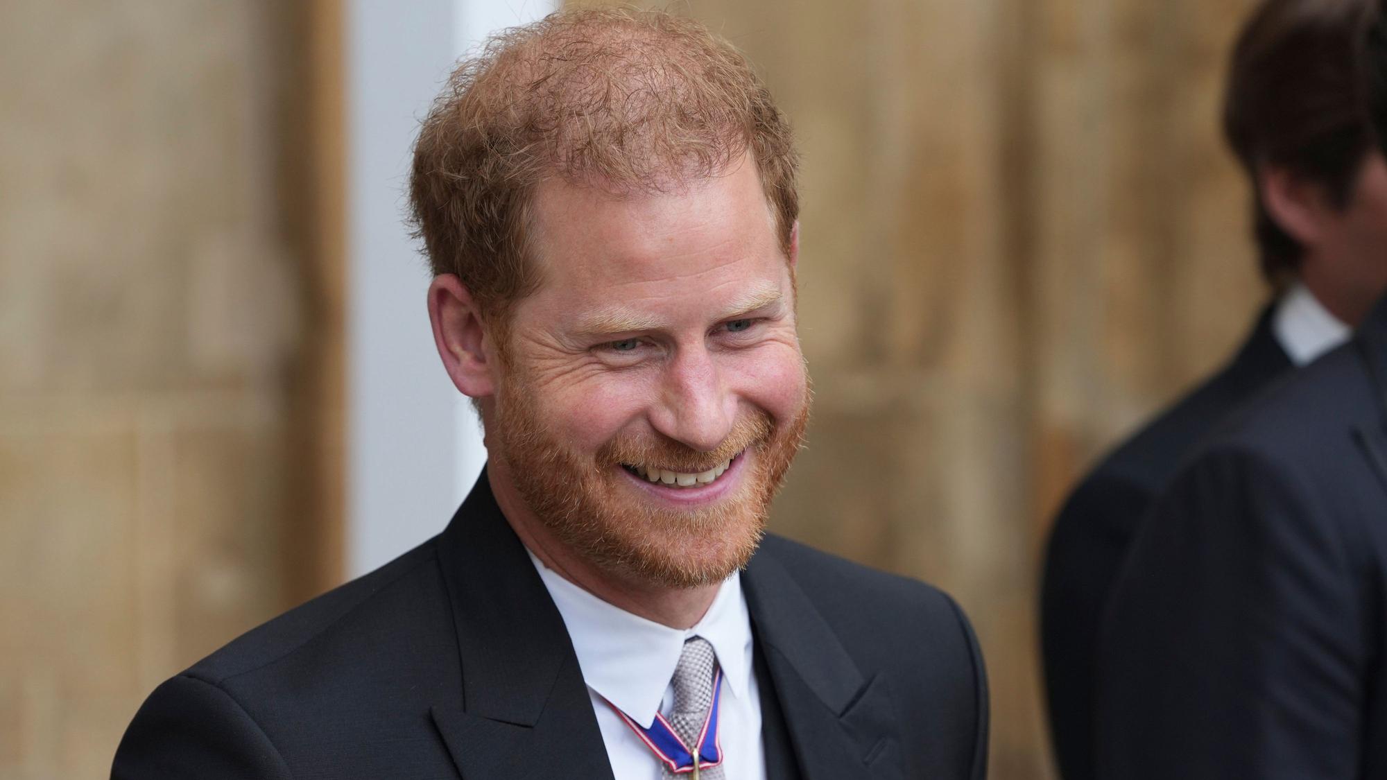Prinz Harry, Herzog von Sussex, verlässt nach der Krönung von König Charles III. und Königin Camilla die Westminster Abbey und lächelt.