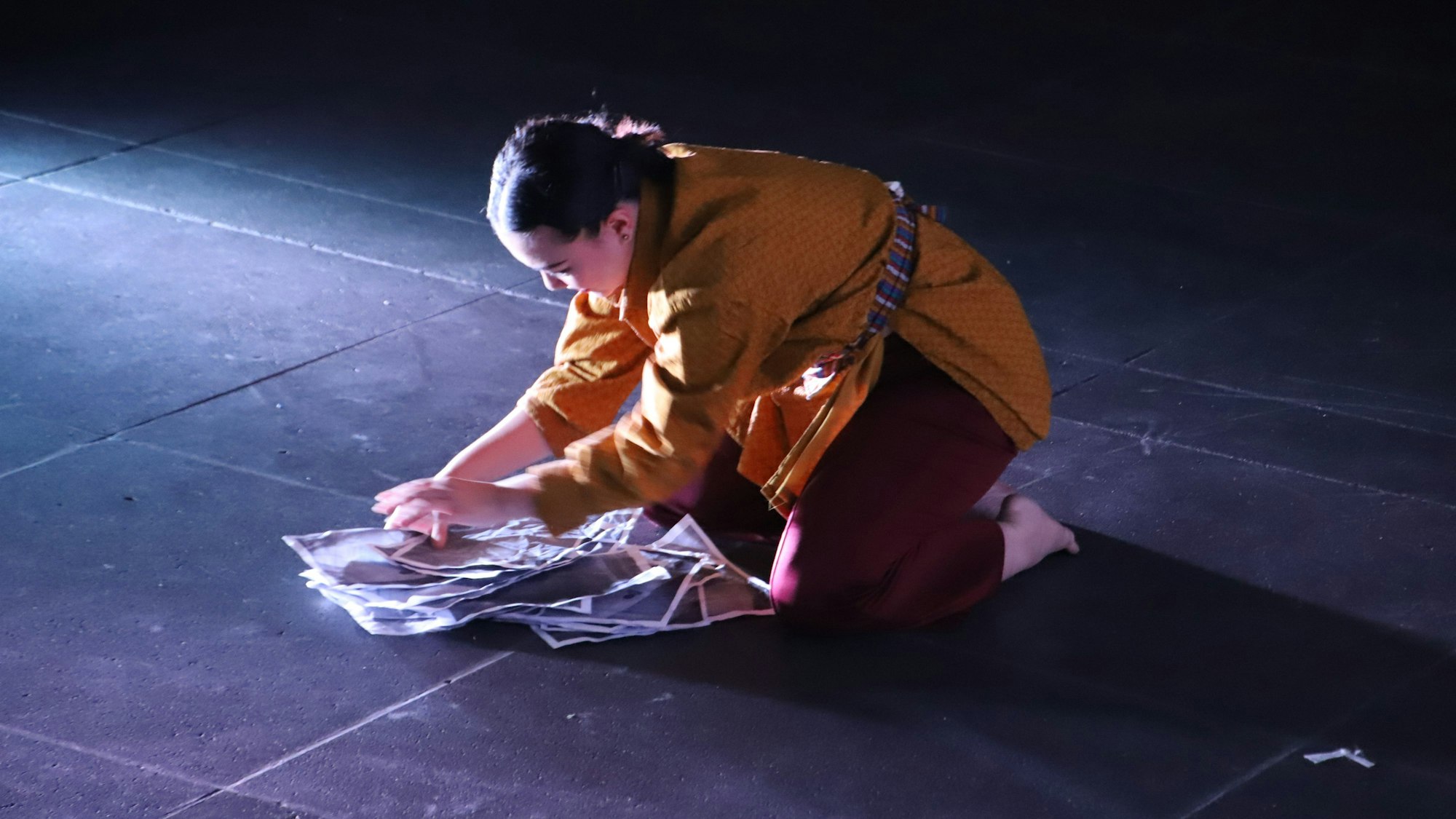 Eine Tänzerin tanzt mit Papieren.