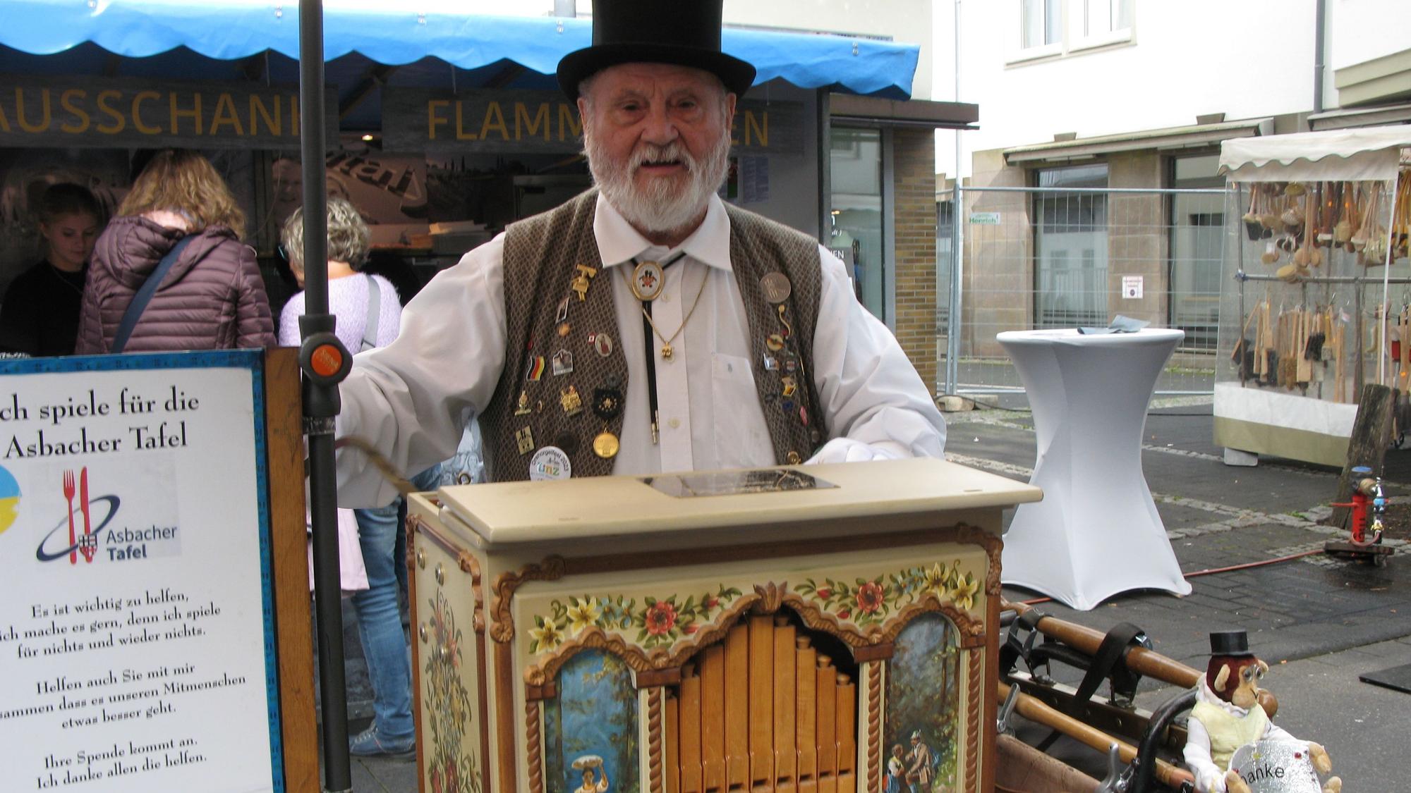 Ein älterer Mann mit Zylinder mit einer nostalgischen Drehorgel.