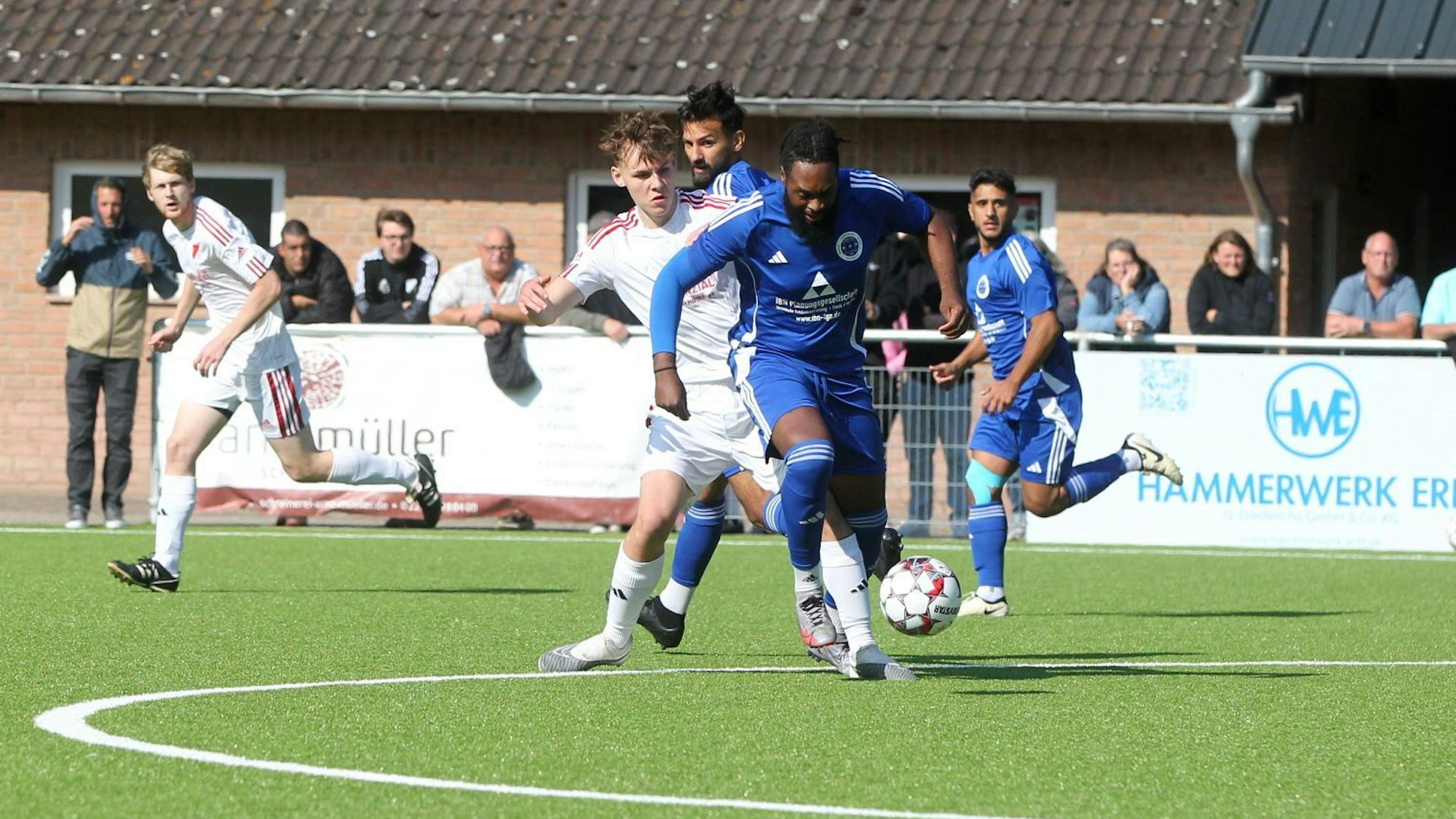 Ein Fußballer wird im Mittelkreis von einem Gegenspieler attackiert.