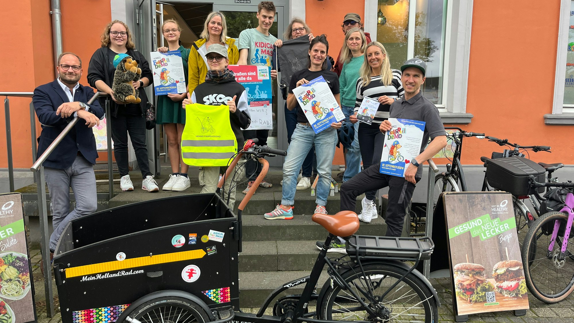 Ein großes Vorbereitungsteam für eine Fahrraddemo hat sich auf einer Treppe versammelt.