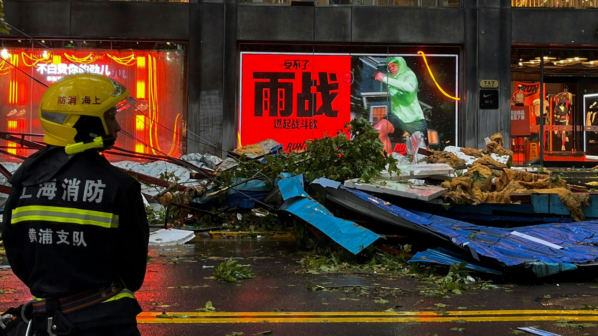 Ein Feuerwehrmann steht vor Trümmern auf einer Straße in Shanghai.