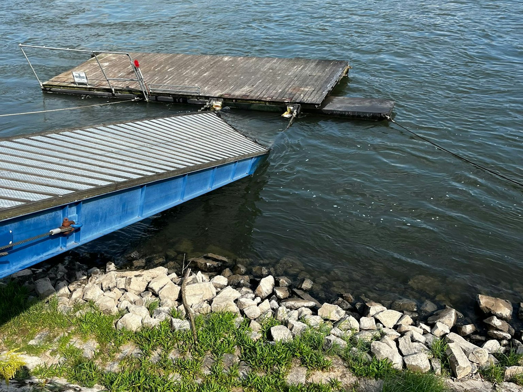 Der Steg des Bonner Ruder-Vereins 1882 e.V. hängt nach einem Unfall mit einem Frachtschiff schräg ins Wasser.