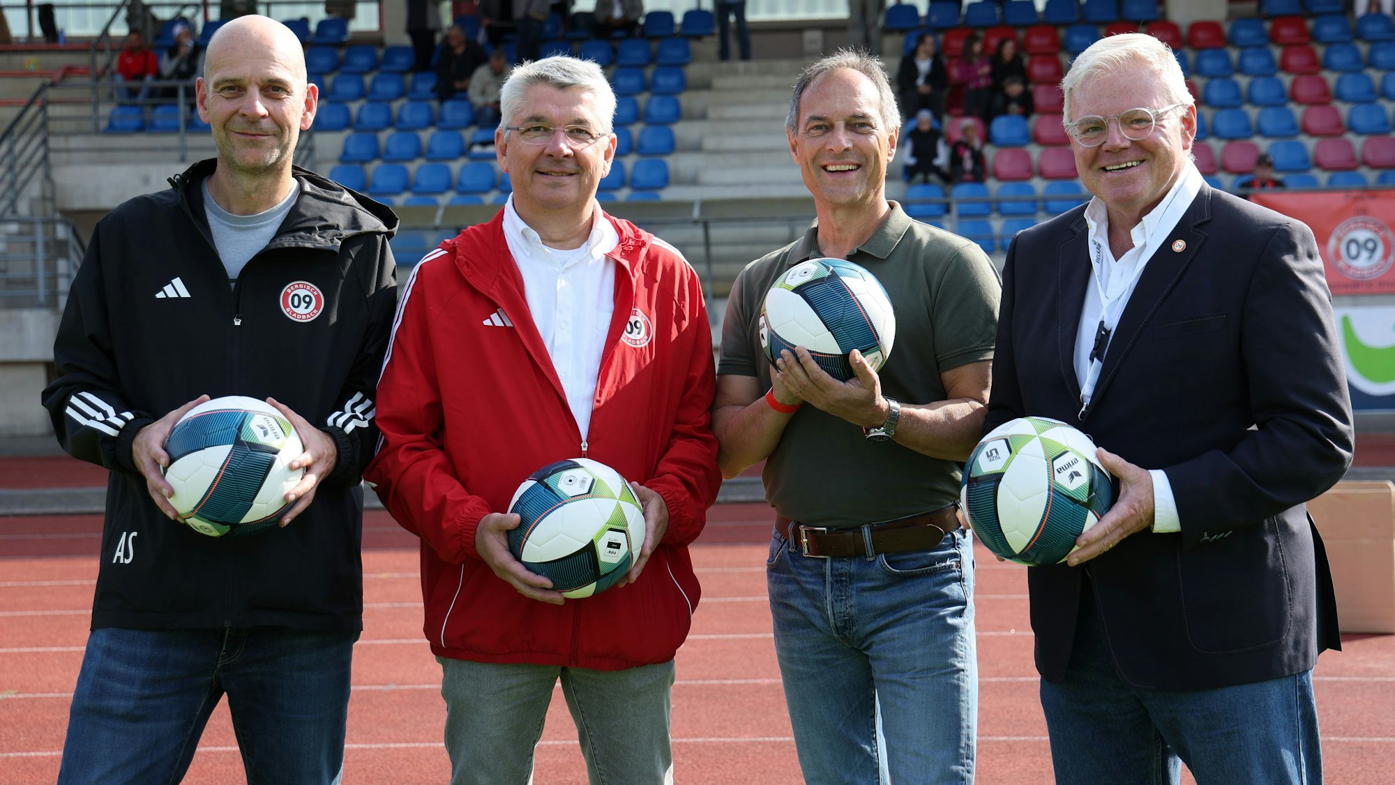 Alex Schiele, Lutz Urbach, Manfred Habrunner und KD Becker stehen vor der Tribüne der Belkaw-Arena