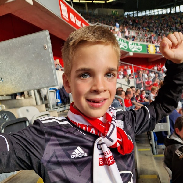Justus (9) im Stadion, er reckt die Faust