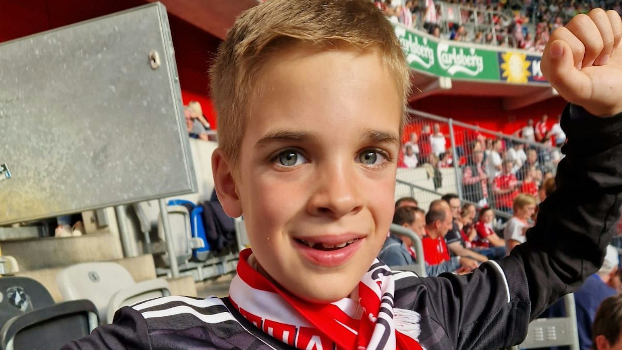 Justus (9) im Stadion, er reckt die Faust