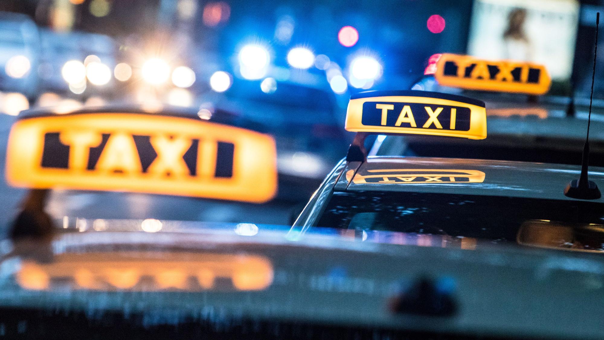 Das Bild zeigt die Dächer von drei Taxis bei Nacht.