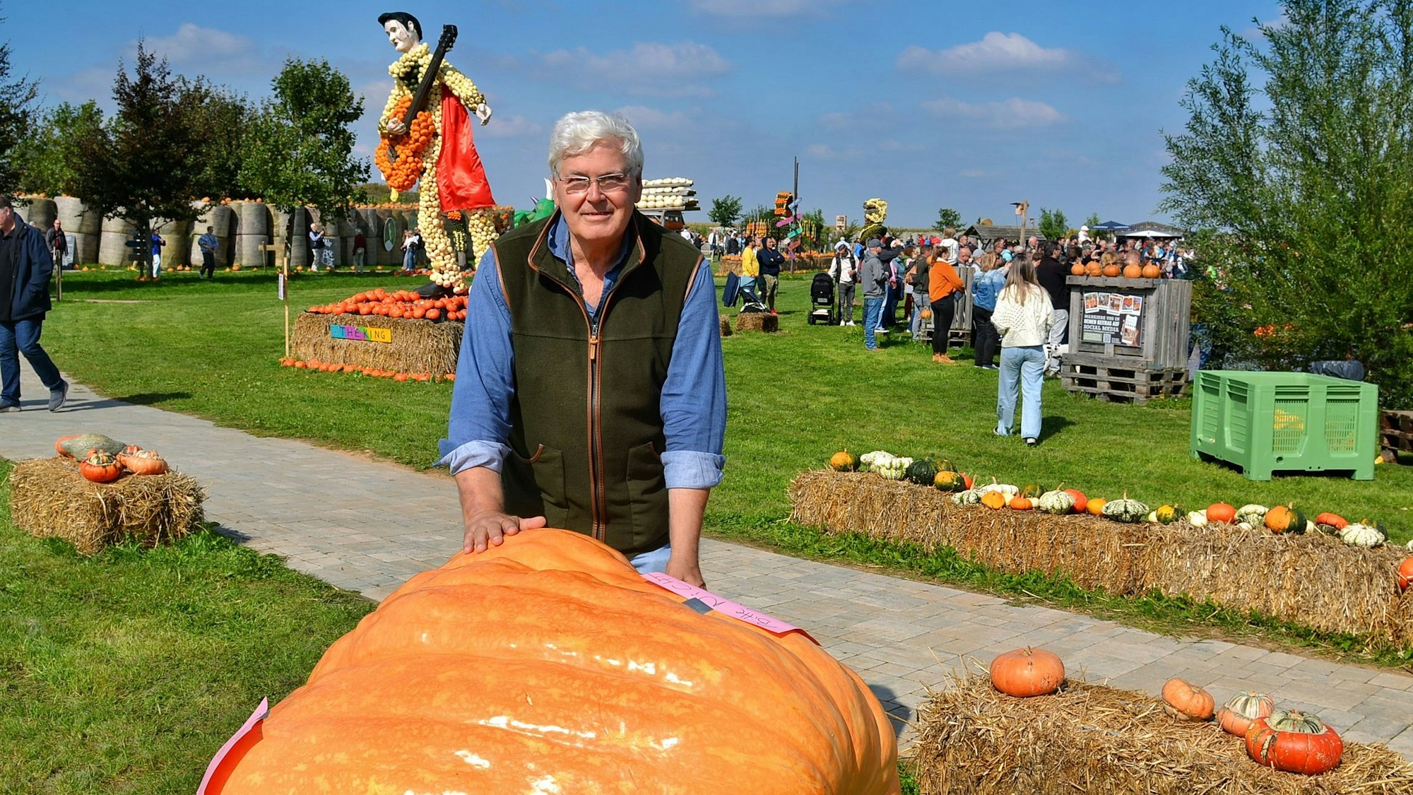 Theo Bieger steht an einem Riesenkürbis.
