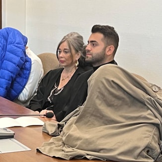 Die Angeklagten – mit den Verteidigern Petra Wunsch und Salih Kocak – verstecken ihre Gesichter vor den Pressekameras.