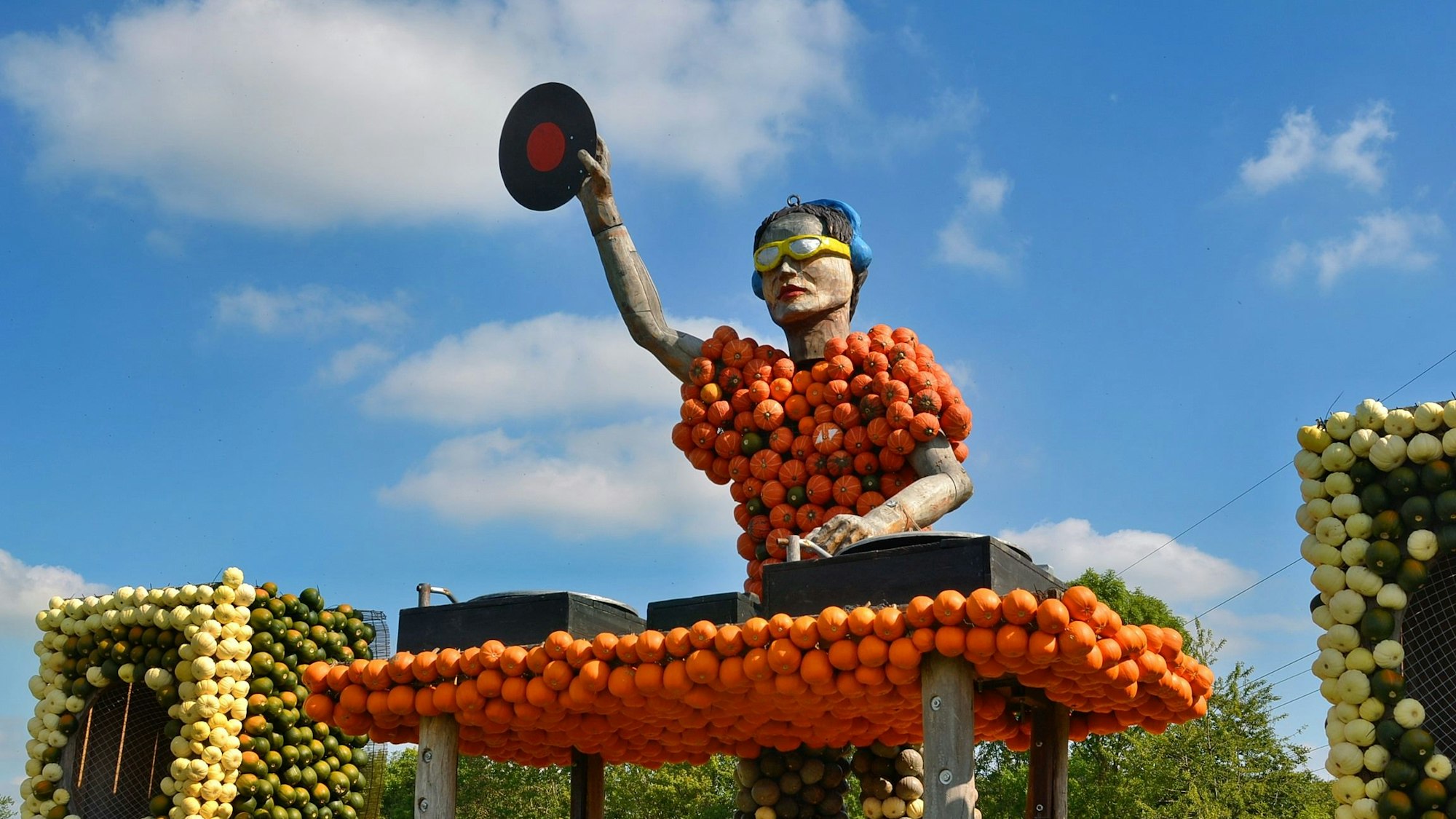 Eine der Skulpturen stellt einen DJ mit Sonnenbrille dar, vor sich zwei Plattenspieler, in der Hand eine Schallplatte.