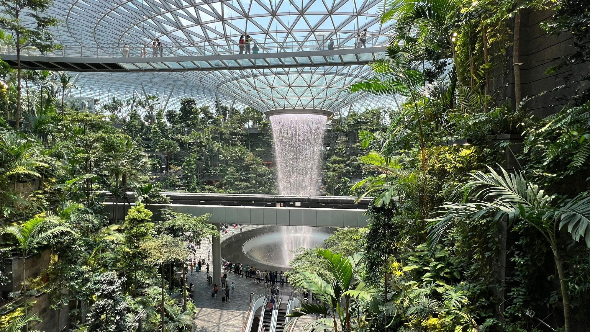 Blick in den Gebäudekomplex. Viel Grün und ein imposanter Wasserfall.