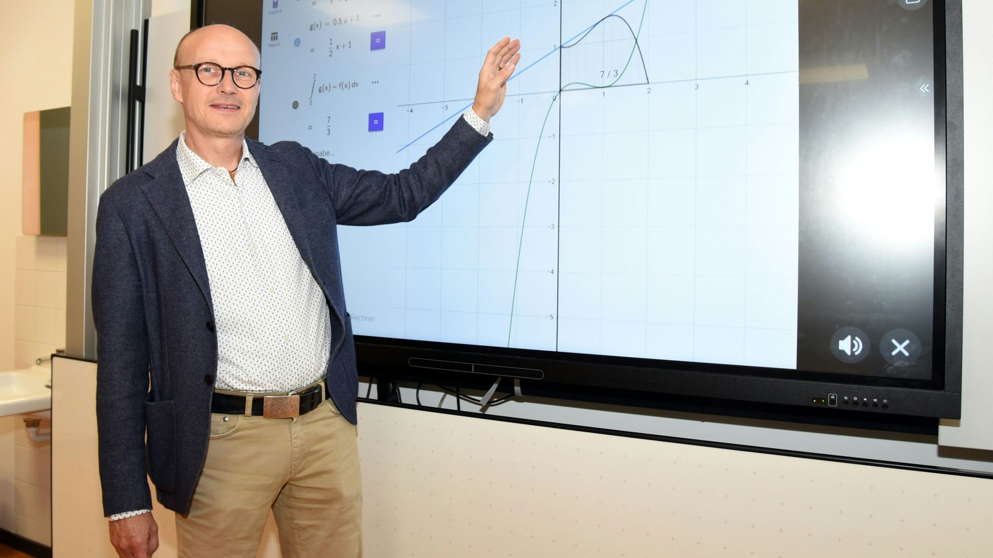 Das Foto zeigt den neuen Schulleiter Christoph Straube vor einer elektronischen Tafel.