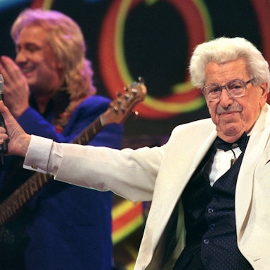 Willy Millowitsch dirigiert während seiner Gesangseinlage die Gäste eines Gala-Abends in der KölnArena.