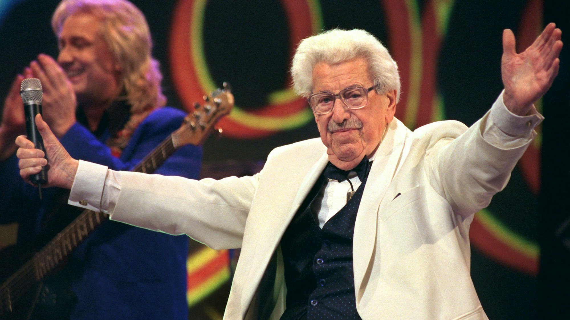 Willy Millowitsch dirigiert im Januar 1999 während seiner Gesangseinlage die Gäste eines Gala-Abends in der KölnArena. (Archivbild)