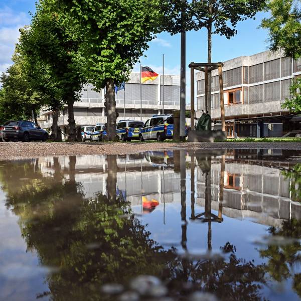 Außenaufnahme des Bundesverfassungsgerichtes, das sich in einer Pfütze spiegelt.