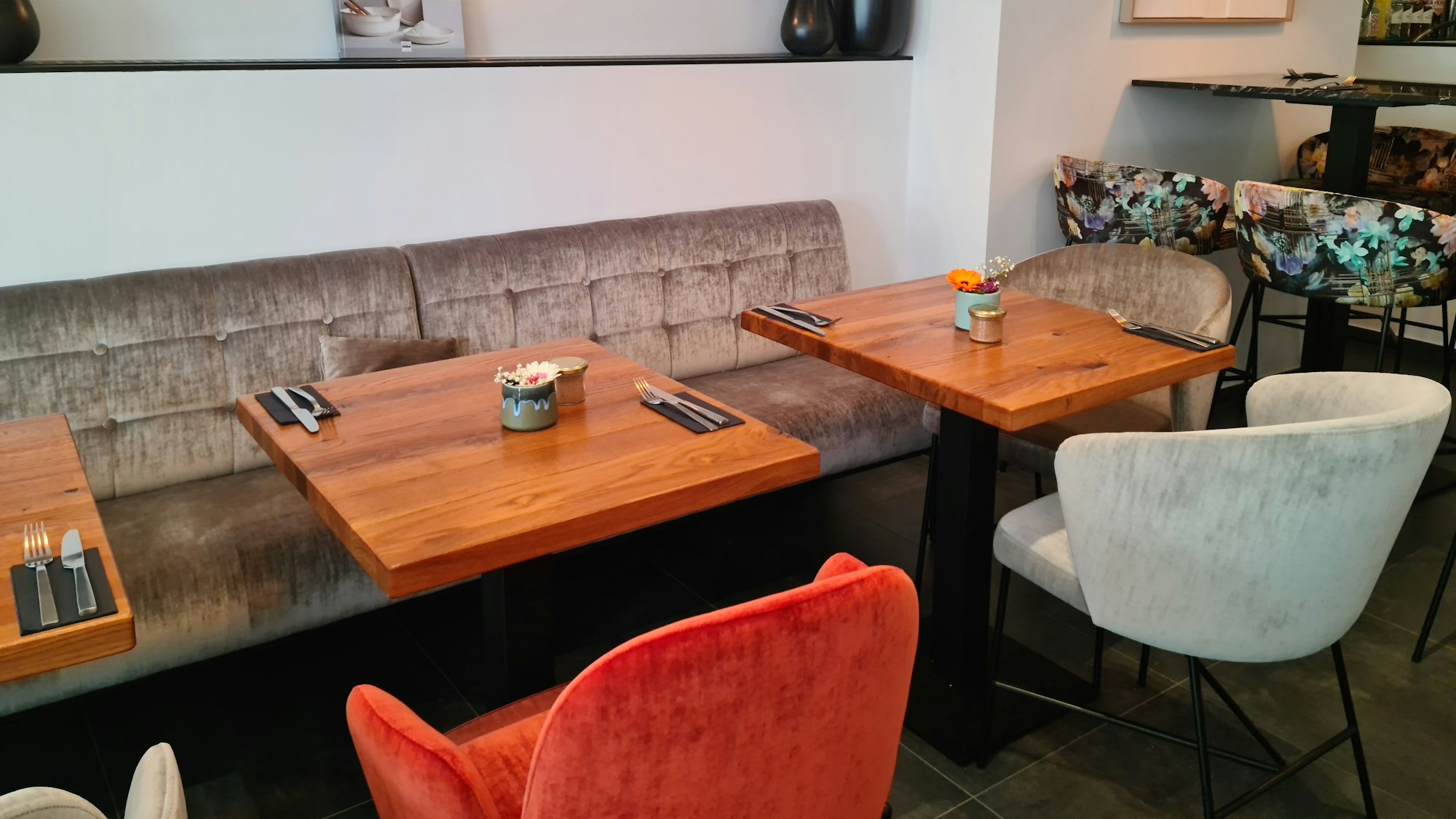 Viele Zweiertische mit farbigen Sesseln finden sich im Esszimmer.