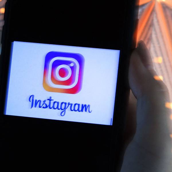Das Logo der Meta-App Instagram leuchtet auf einem Handy-Display auf.