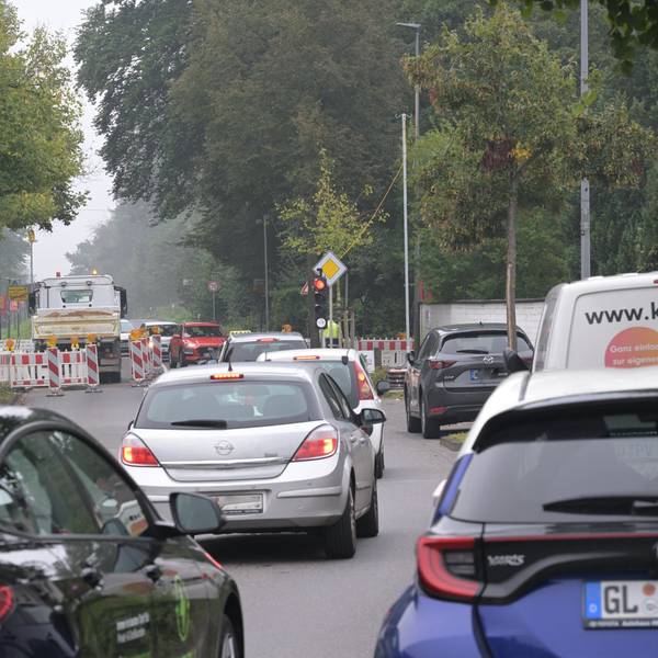 Vor der Baustellenampel stehen Autos im Stau.