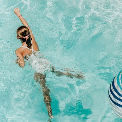 Ein Mädchen schwimmt in einem Pool.