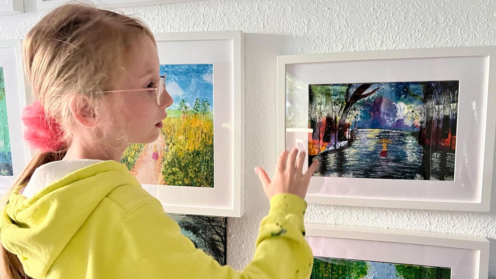 Die elfjährige Carolina Neubauer zeigt eins ihrer selbstgemalten Lieblingsbilder in ihrer Wohnung.