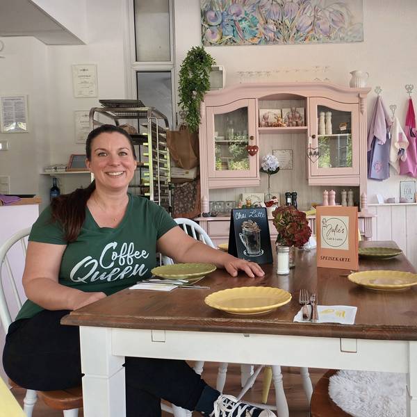 Eine Frau sitzt an einem Café-Tisch