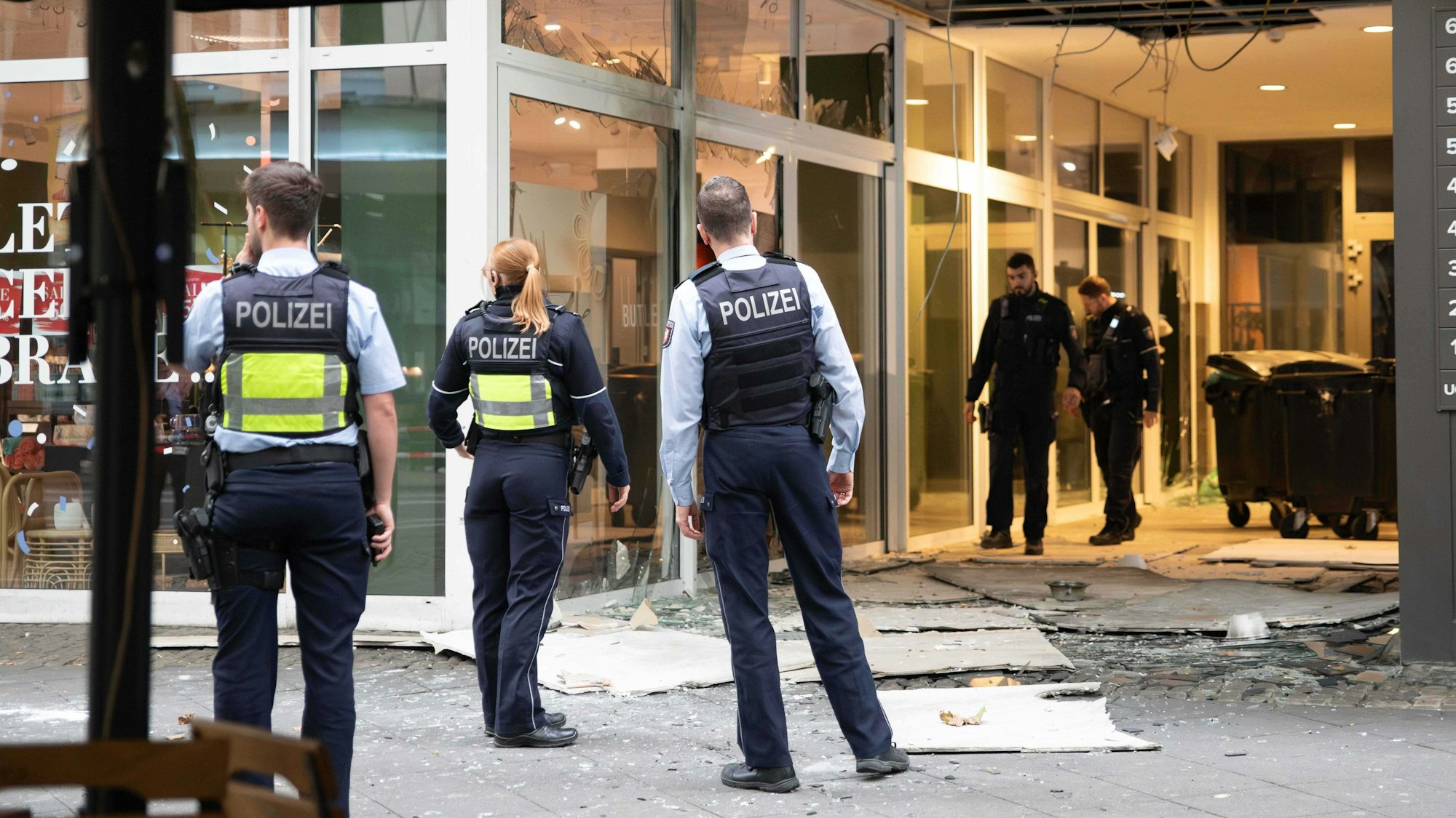 Polizeibeamte stehen nach einer Explosion vor einem beschädigten Gebäude in der Innenstadt am Hohenzollernring.