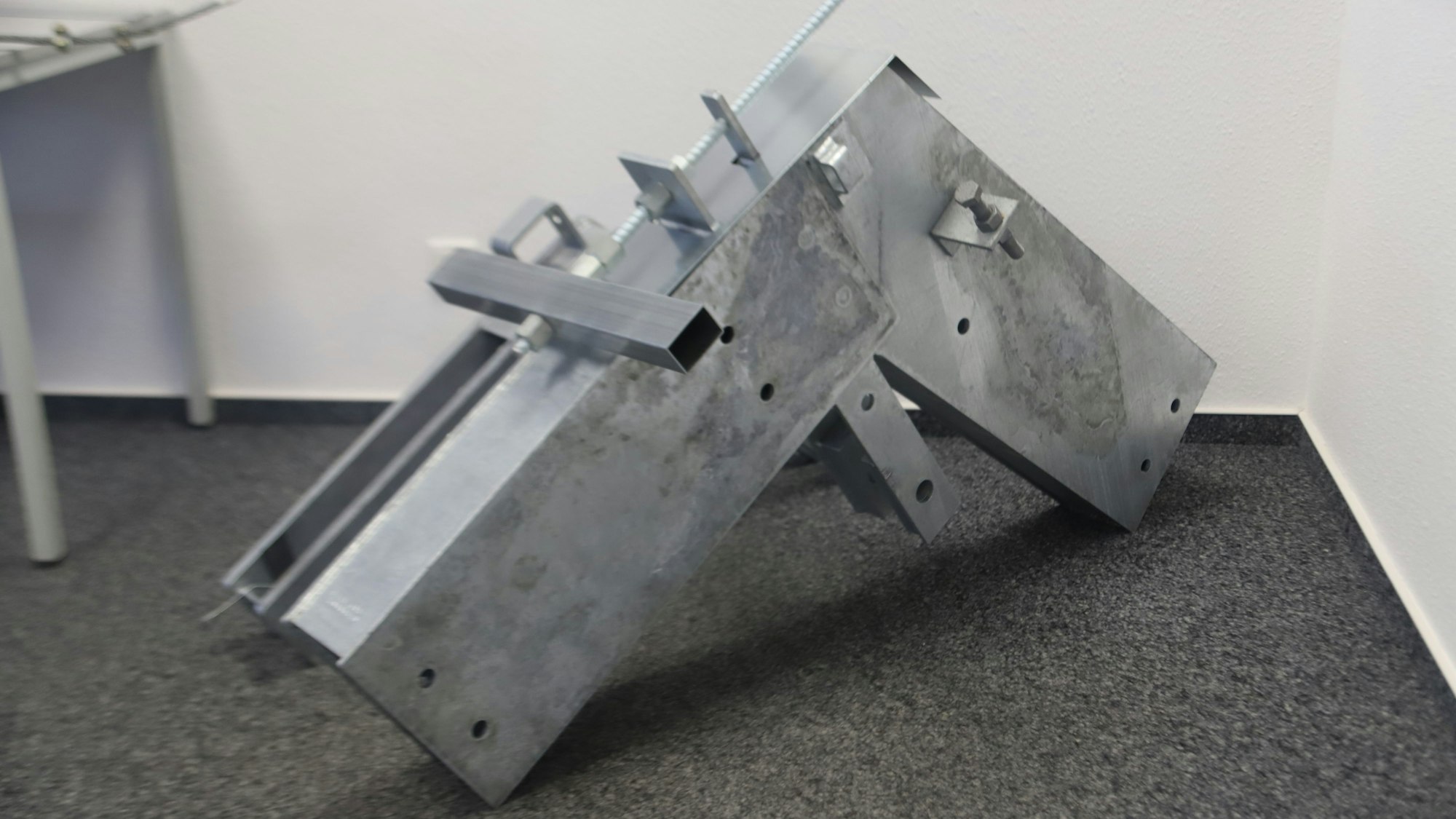 In der Ecke eines Raumes steht ein großer Stahlverbinder für den Hallenbau.