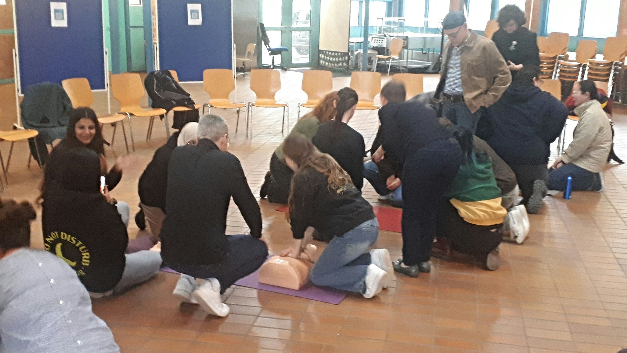 Die Klasse der Notarfachangestellten übt an Modellpuppen gemeinsam die Herzdruckmassage.