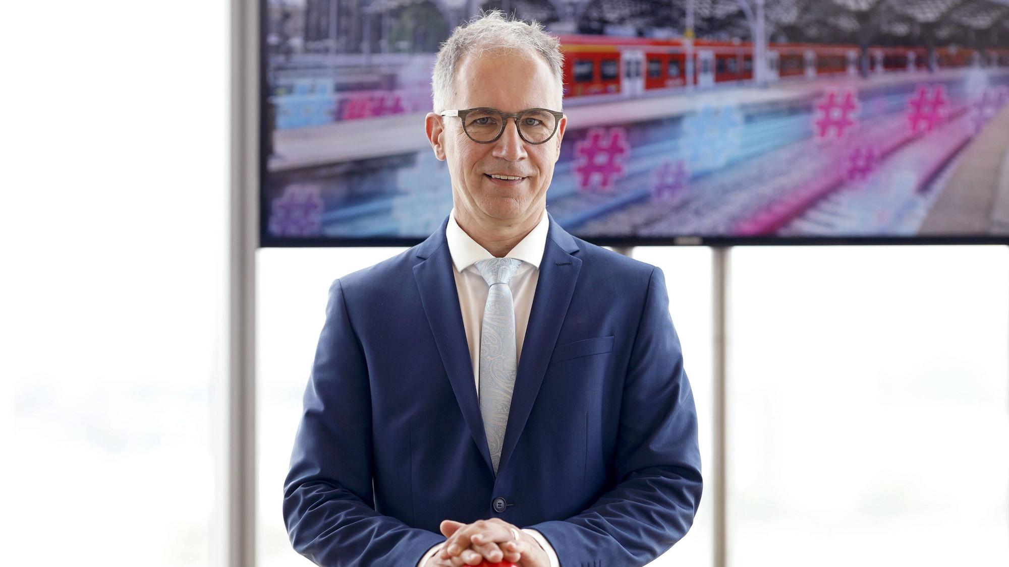 Norbert Reinkober steht vor einem Bildschirm.