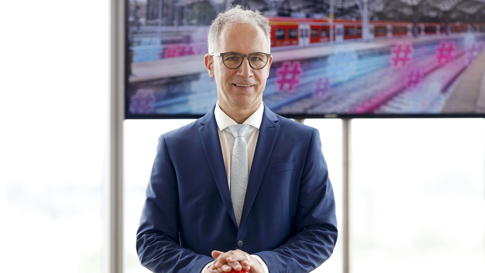 Norbert Reinkober steht vor einem Bildschirm.