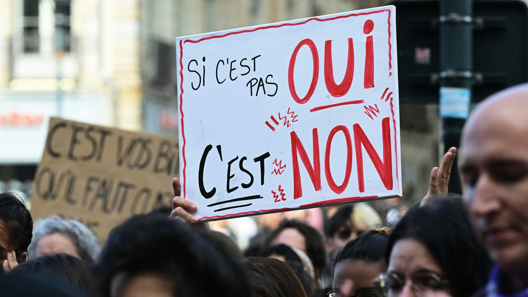 Eine Demonstrantin hält bei Protesten zur Unterstützung von Gisèle Pelicot in Rennes ein Schild hoch. „Wenn es kein ‚Ja‘ ist, dann ist es ein ‚Nein‘“, lautet die deutsche Übersetzung der Aufschrift des Plakats.