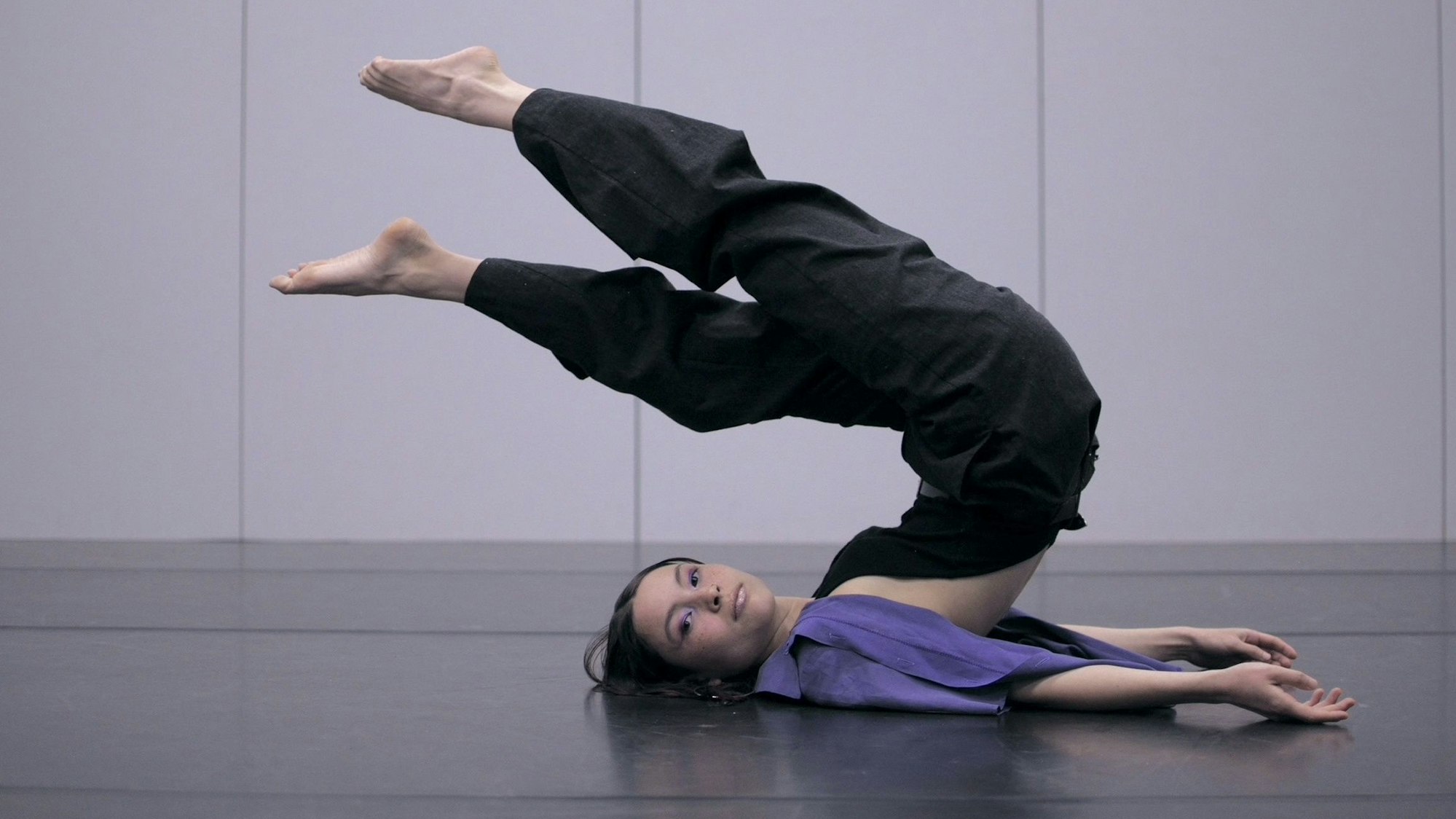 Eva Swiderski liegt auf dem Boden und turnt.