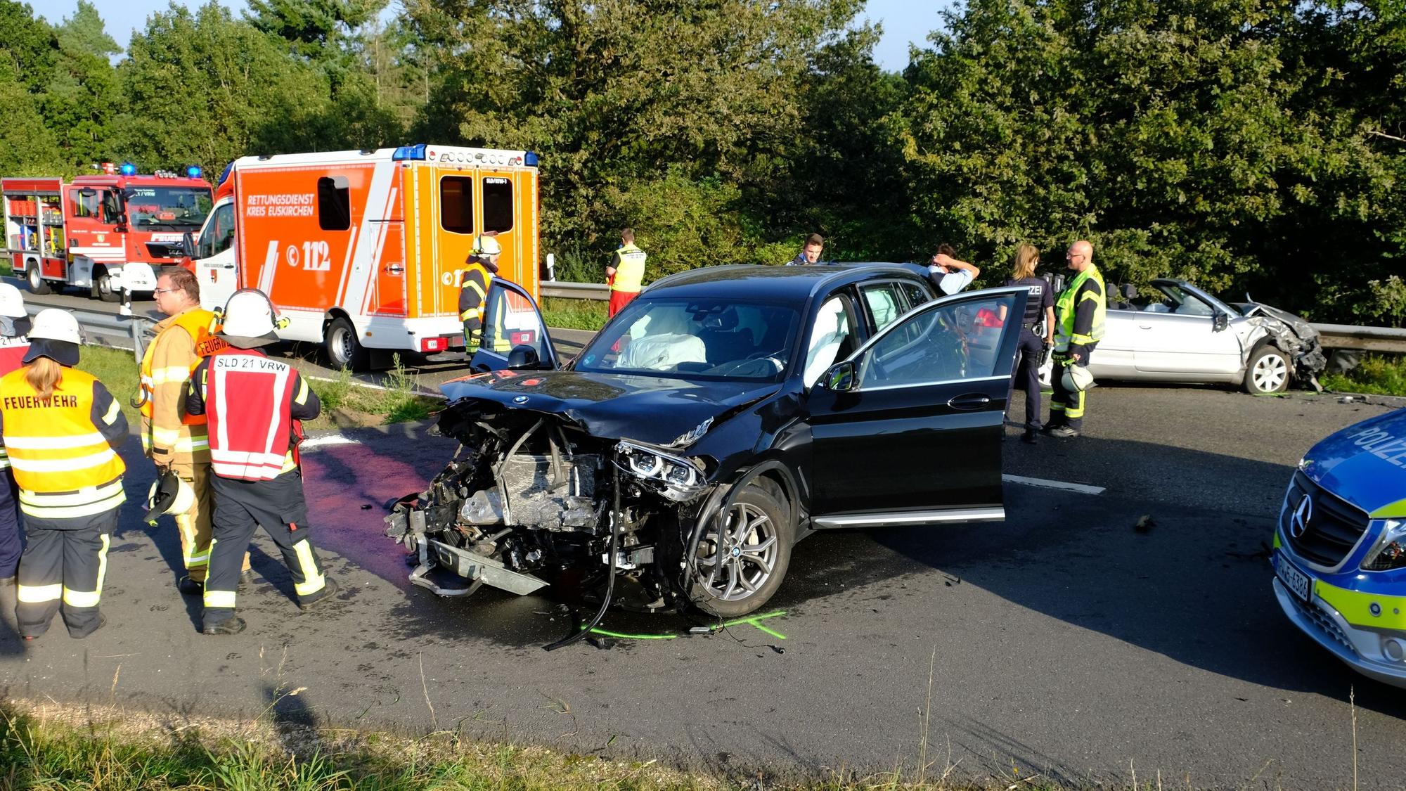 Einsatzkräfte von Feuerwehr, Rettungsdienst und Polizei stehen am Unfallort bei Herhahn um die beiden beteiligten Fahrzeuge herum.