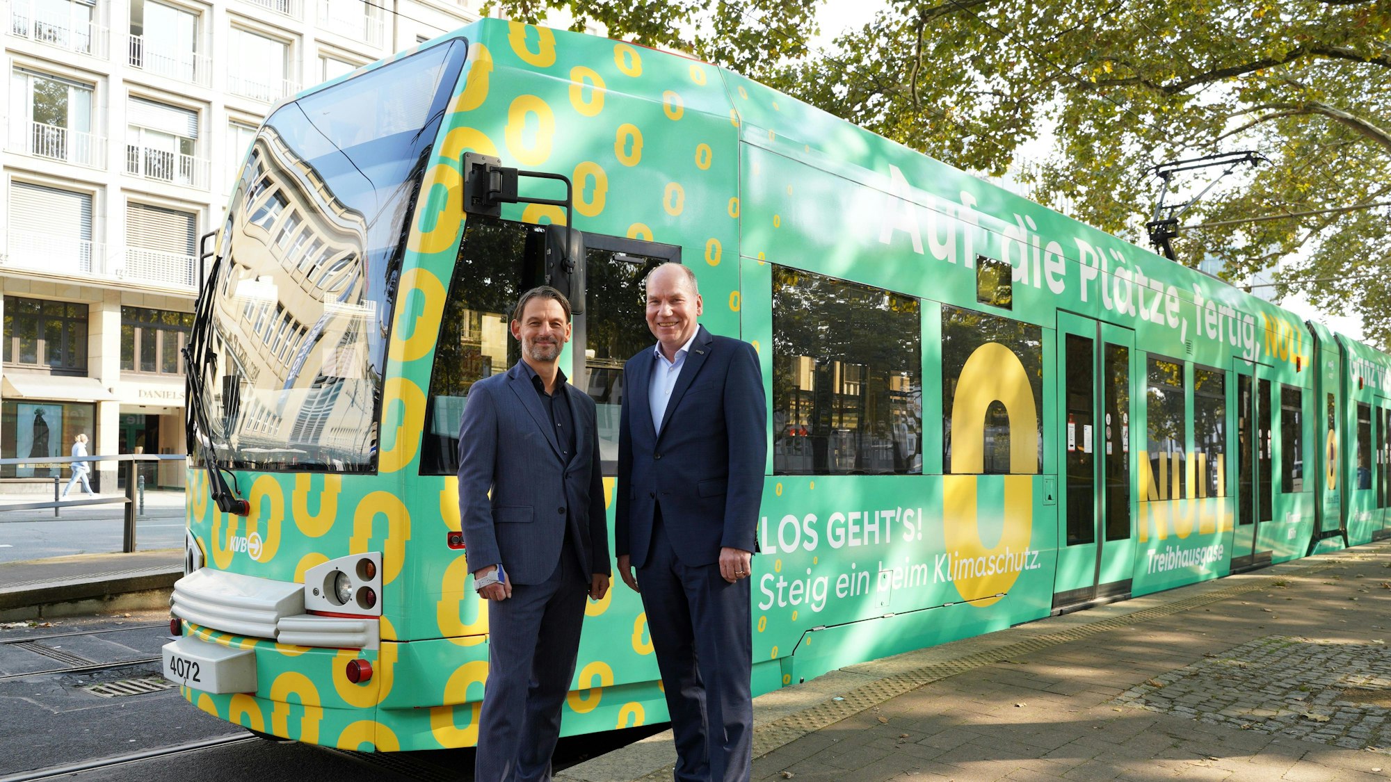 William Wolfgramm, Klimadezernent, und KVB-Vorstand Jörn Schwarze vor der neu bedruckten „Klimabahn Köln“.