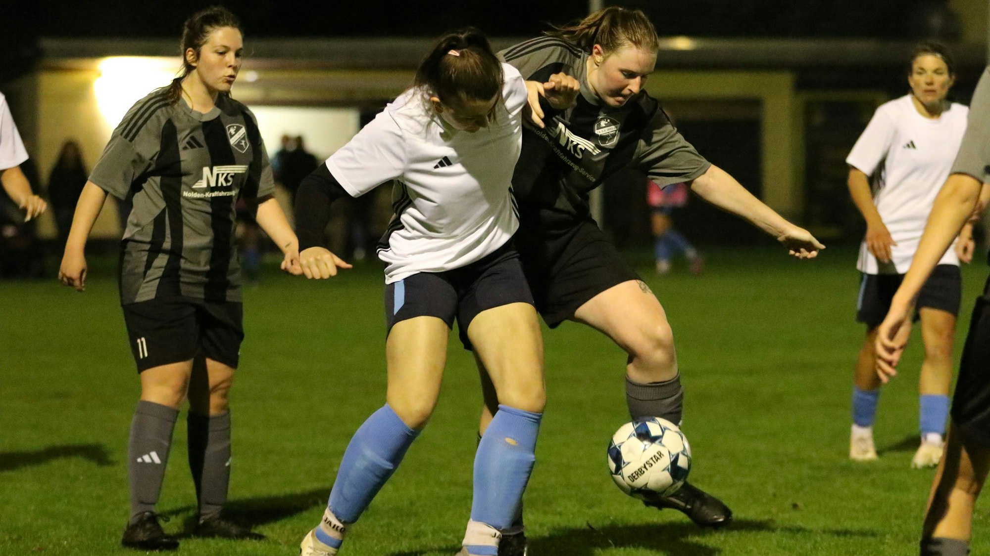 Zwei Spielerinnen von Kommern und Füssenich-Geich kämpfen um den Ball. Dabei setzen sie auch ihre Körper ein.