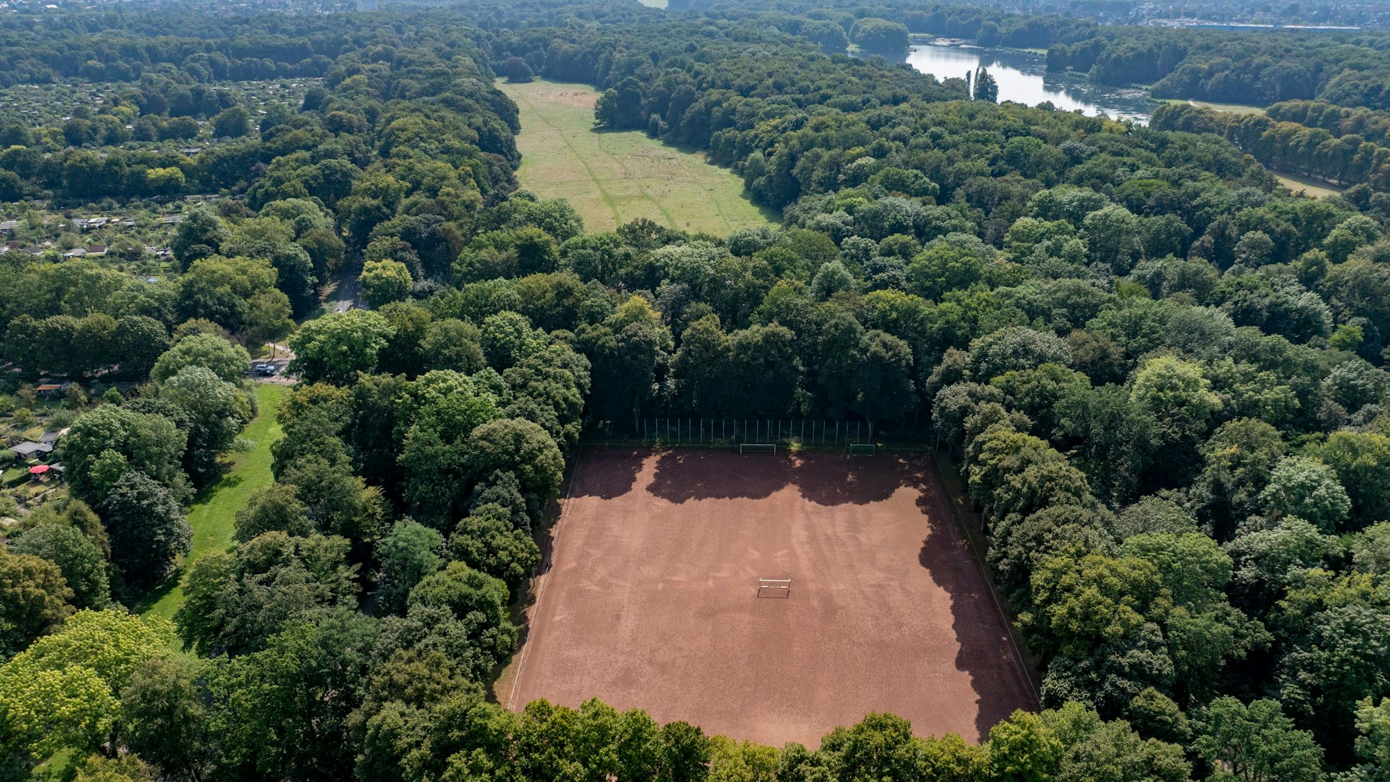 Blick auf den Aschenplatz der Bezirkssportanlage Eichenkreuz, die der 1. FC Köln ausbauen will. Die Gleueler Wiese (hinten) ist erstmal keine Option mehr.