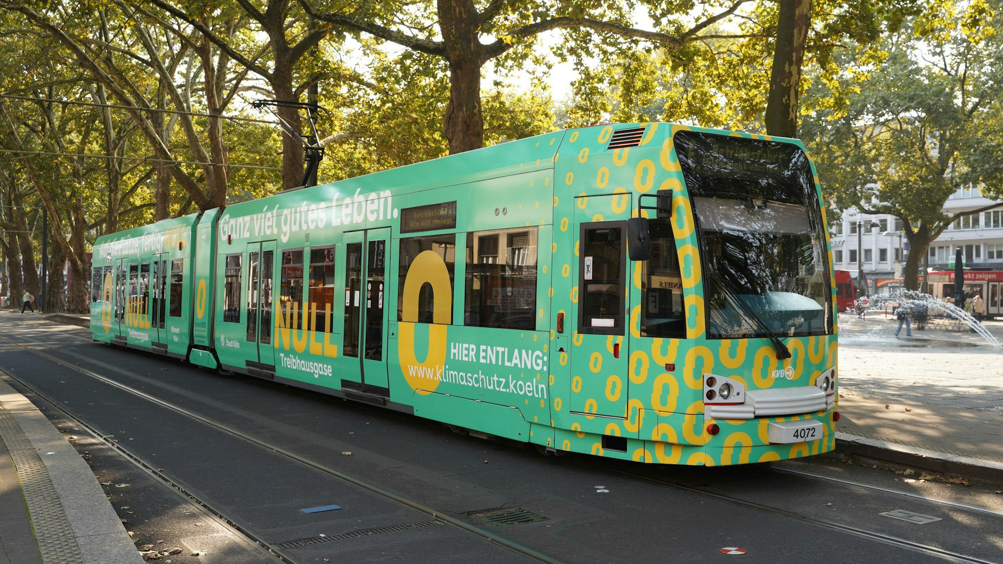 Eine grüne Bahn mit der Beschriftung: „Hier entlang: www.klimaschutz.koeln.“