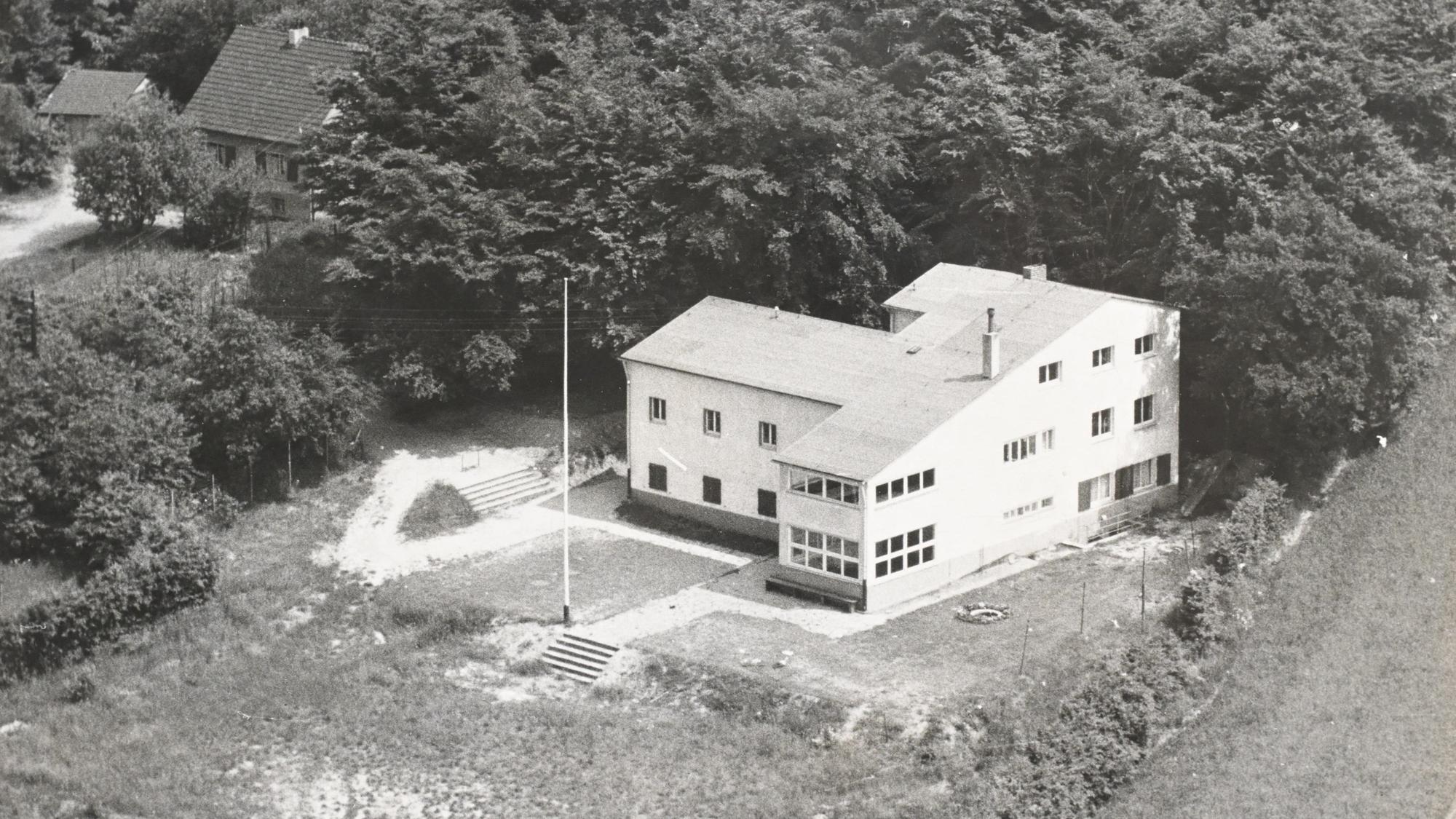 Ein Neubau eines Hauses in den 1930 Jahren. Um das Haus ist viel freies Gelände.