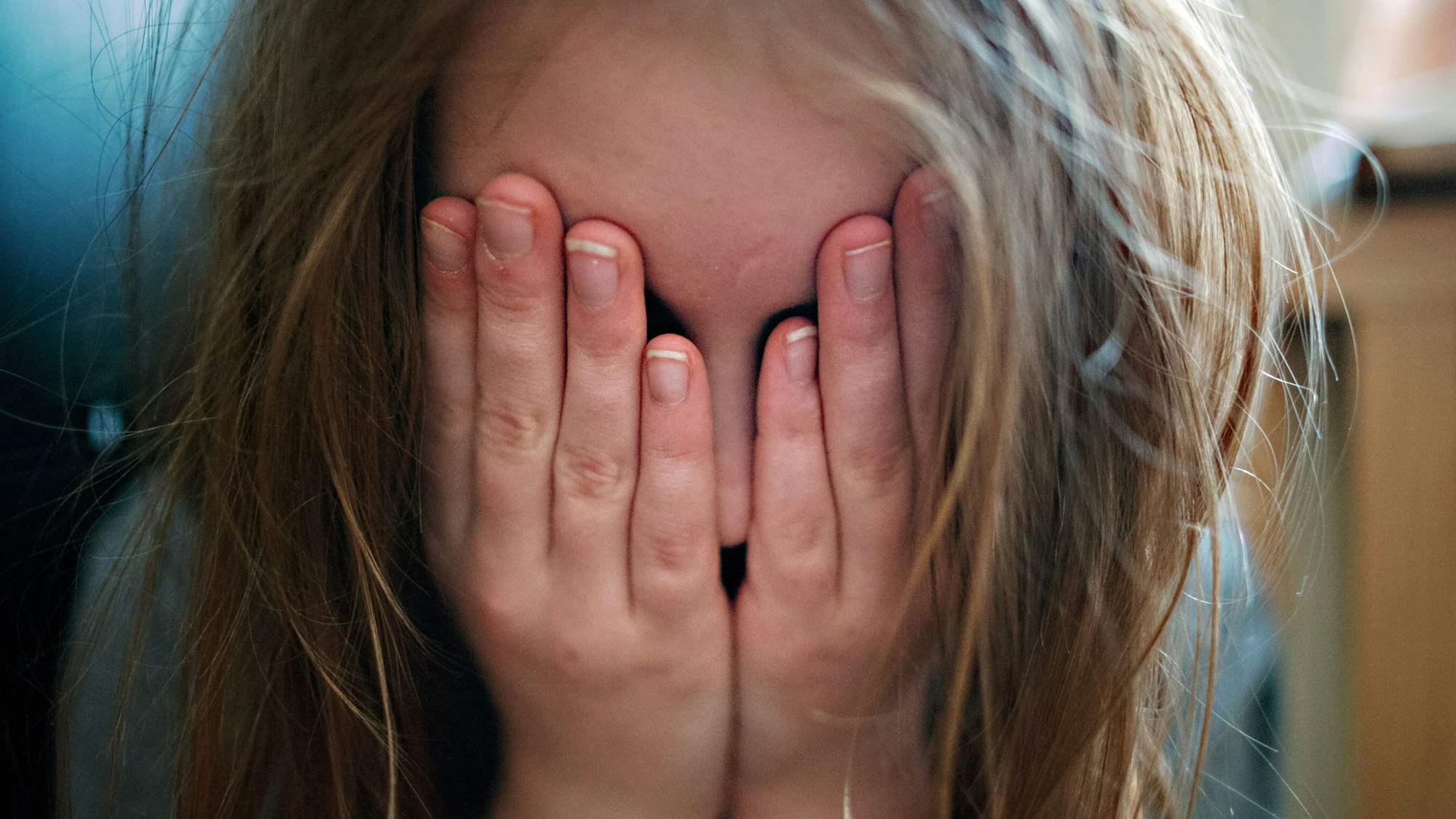 ILLUSTRATION - Ein junges Mädchen hält sich die Hände vor ihr Gesicht. Die Hinweise auf Kindeswohlgefährdung in Rheinland-Pfalz haben im vergangenen Jahr um 5,6 Prozent zugenommen. (zu dpa «Sorge ums Kindeswohl - Jugendämter gehen mehr als 8700 Meldungen nach») +++ dpa-Bildfunk +++