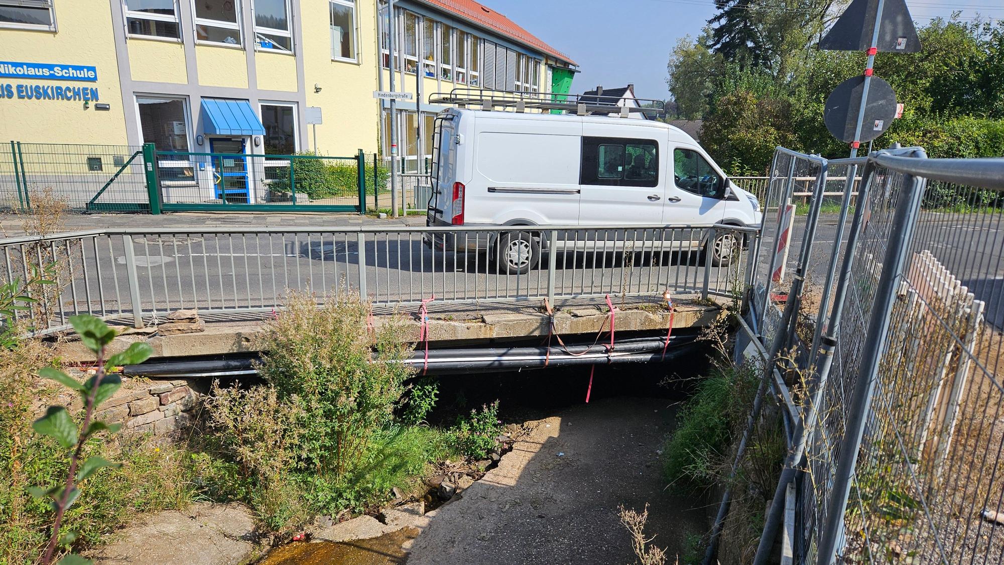 Ein Kleinbus fährt über die Brücke über den Kallbach in Kall.