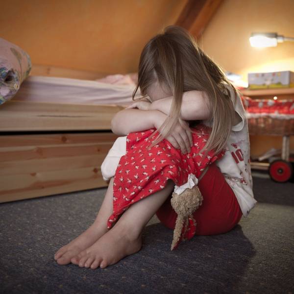 Ein kleines Mädchen sitzt weinend auf dem Fußboden in ihrem Zimmer. F