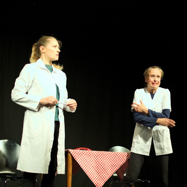 Die Künstlerinnen Melanie Haupt (l.) und Judith Jakob stehen nebeneinander in weißen Kitteln auf der Bühne.
