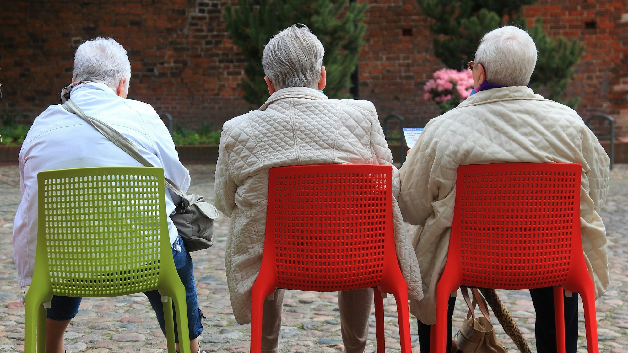 Ältere Besucher der Bundesgartenschau sitzen während einer Pause auf Stühlen. (Archivbild)