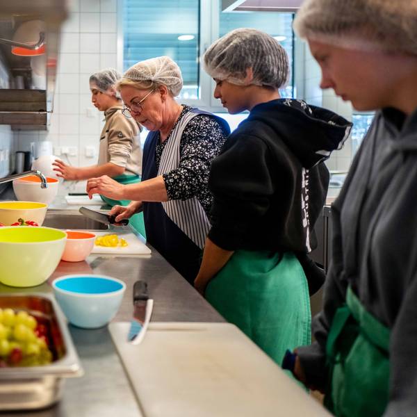 Das Bild zeigt drei Schüler der Stephanus-Schule in Bürvenich beim Schnippeln in der Schulküche. Unterstützt werden sie von einer Lehrerin.