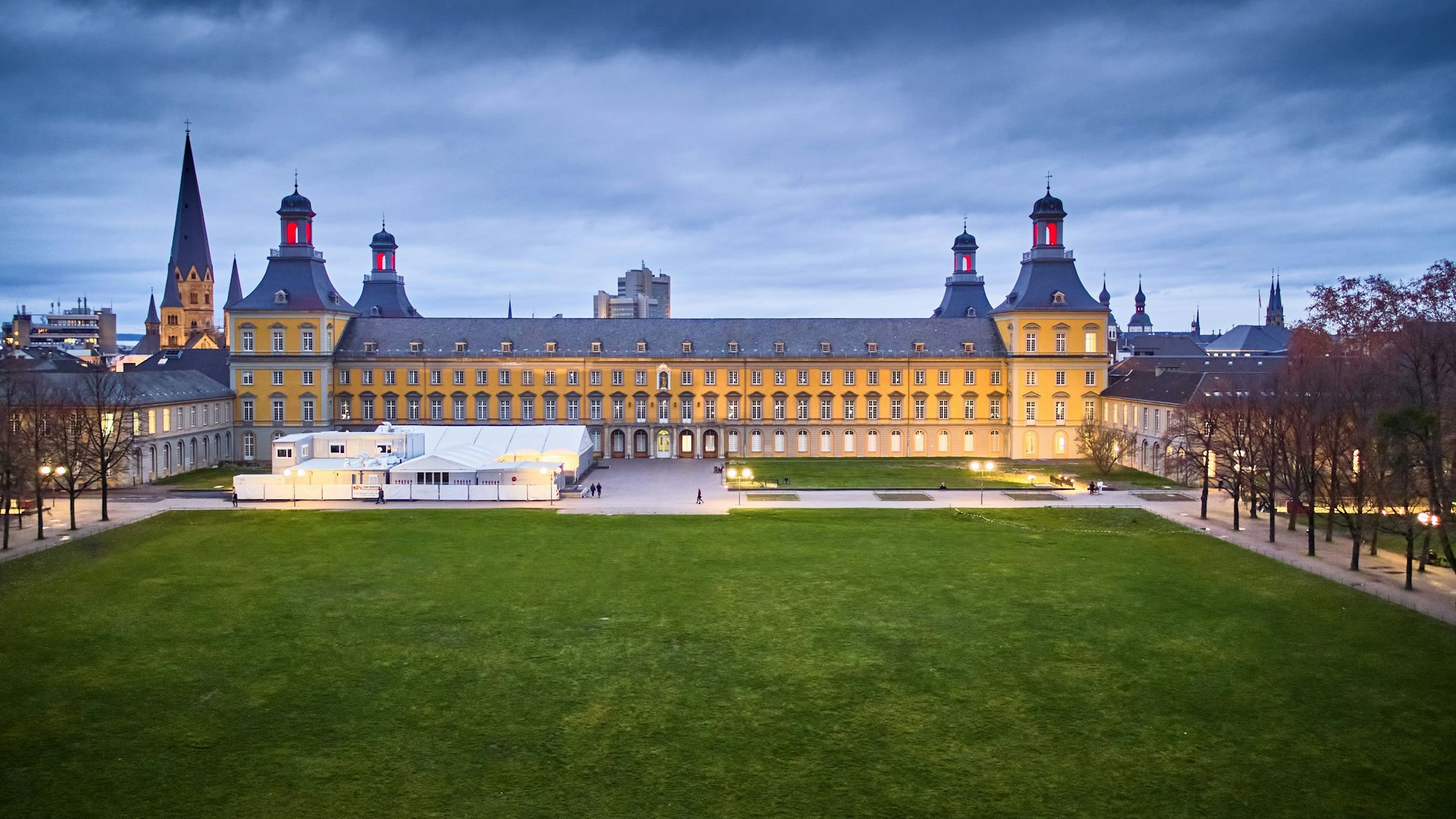 Das Hauptgebäude der Universität Bonn. Die vier Türme leuchten.
