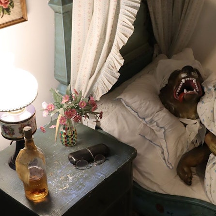 Eine Szene im Märchenwald: Der Wolf liegt als Großmutter verkleidet im Bett. Er sperrt das Maul auf und zeigt seine Zähne.