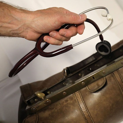 Ein Landarzt nimmt sein Stethoskop aus dem Koffer.