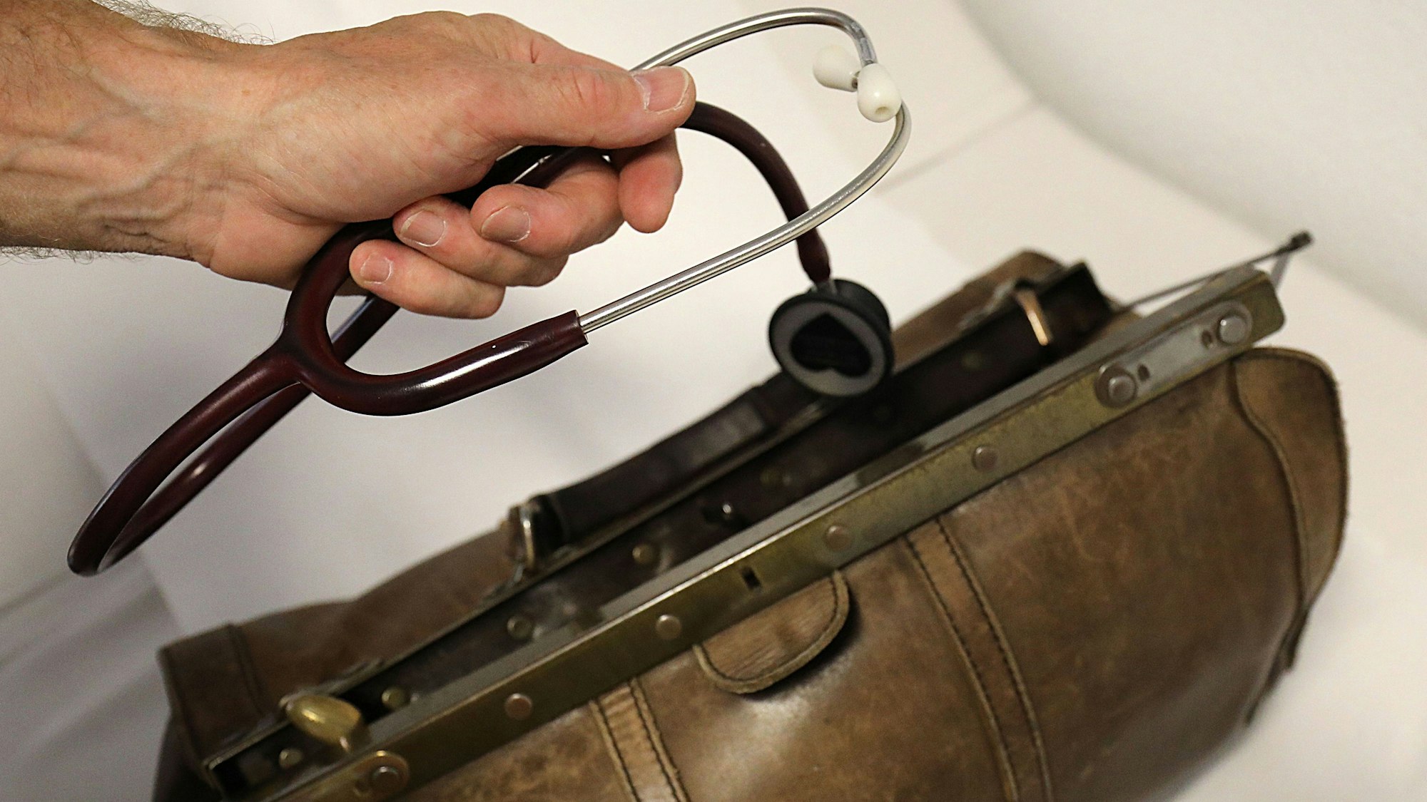 Ein Landarzt nimmt sein Stethoskop aus dem Koffer.